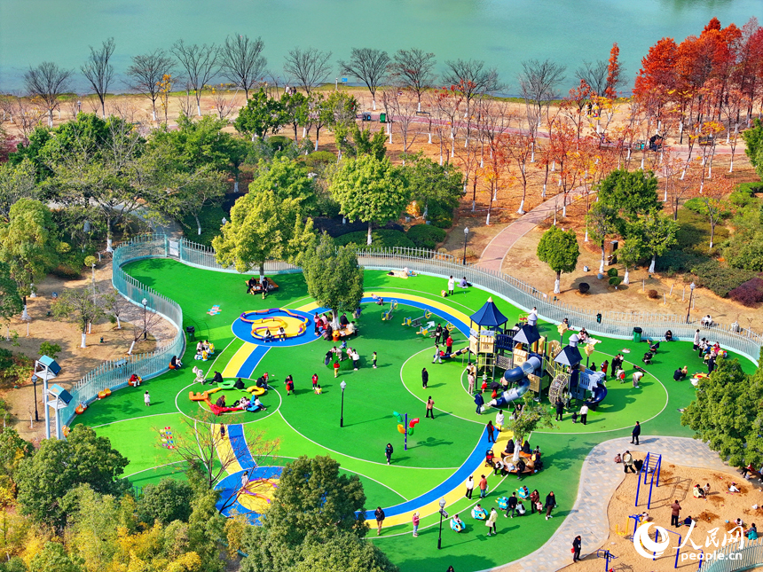贛州市一處公園里的兒童樂園，許多家長陪伴孩子在公園里玩耍，暢享冬日暖陽，體驗新添置的玩樂設施。人民網 朱海鵬攝