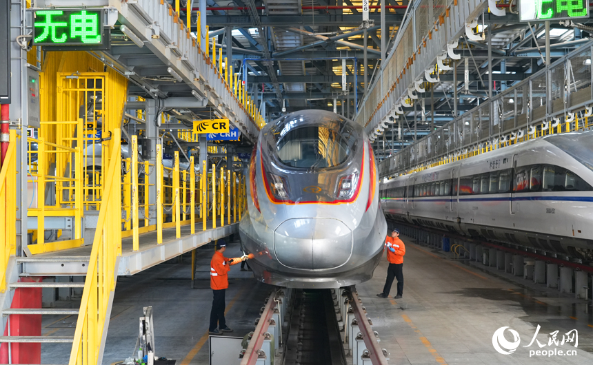 動車組機械師檢查復興號智能動車組兩側。人民網記者 毛思遠攝