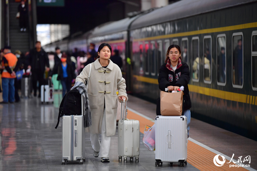 春運首日，推著行李的旅客準備乘車返鄉。人民網記者 時雨攝