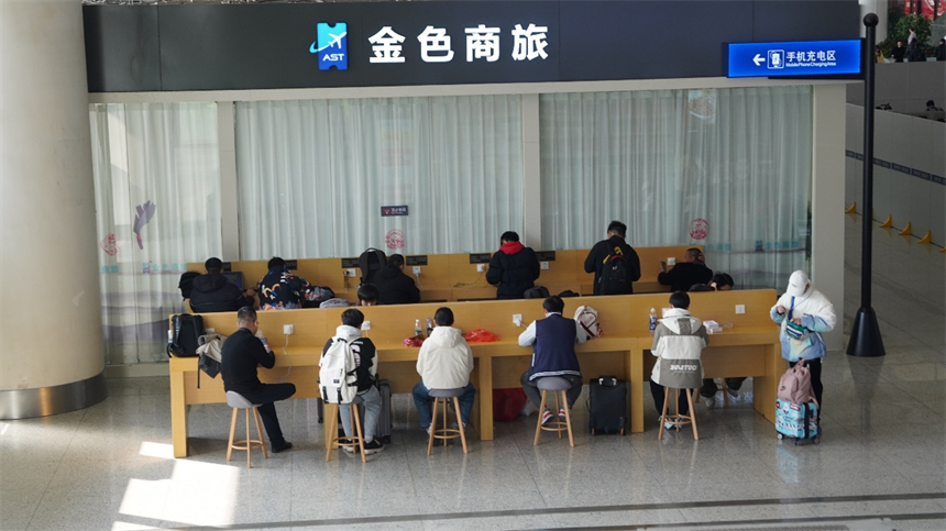 1月22日，乘客在南昌西站候車大廳的手機充電區域短暫休息。王焱茹攝