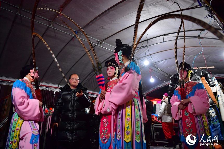 舞臺旁，一名年長的演員正在為候場的年輕演員們講解表演要領。人民網記者 時雨攝