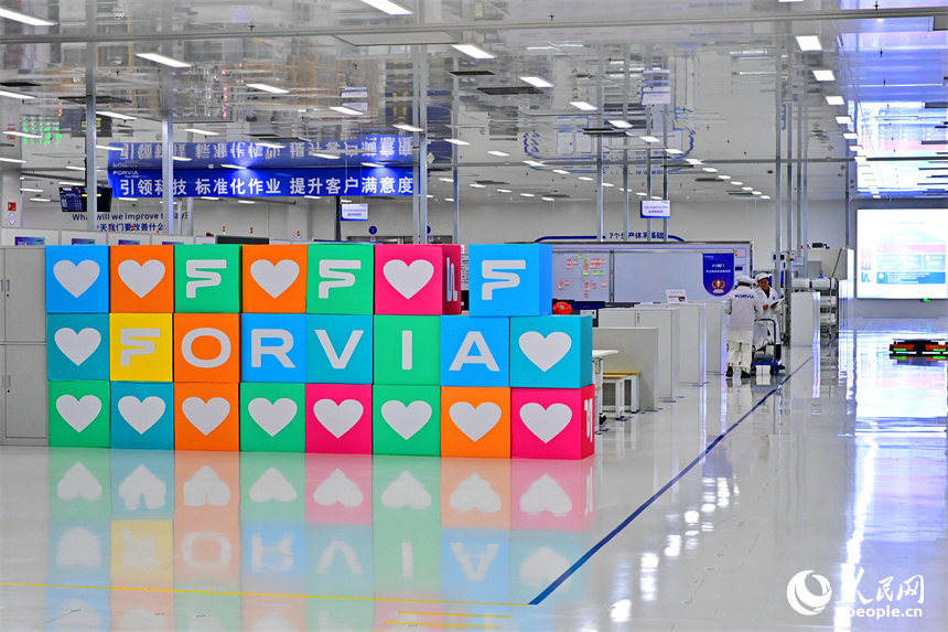 豐城市高新技術產業園區的一家汽車電子企業內，AGV運輸車來回運轉有序作業，工人在加工車載電子產品。人民網 朱海鵬攝