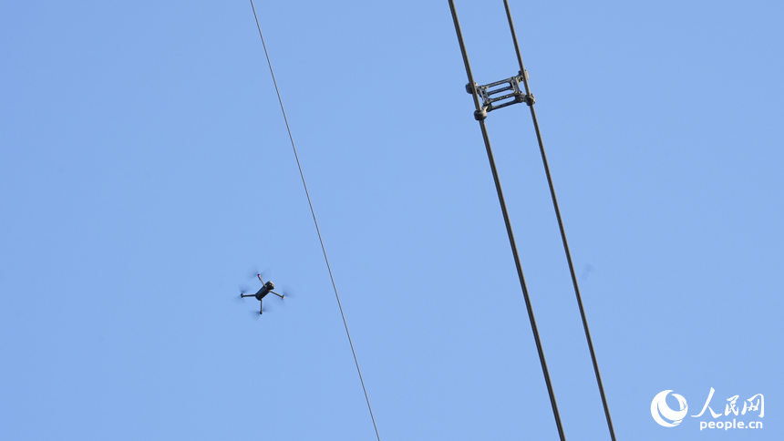 江西送變電公司輸電運檢分公司九江巡檢站檢修人員正在操作無人機對導線進行檢測。人民網 孔文進攝