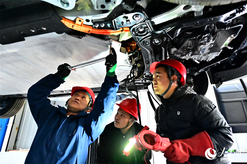 新能源汽車運維專業學生在老師的指導下學習新能源汽車電池包檢修技術。人民網 朱海鵬攝
