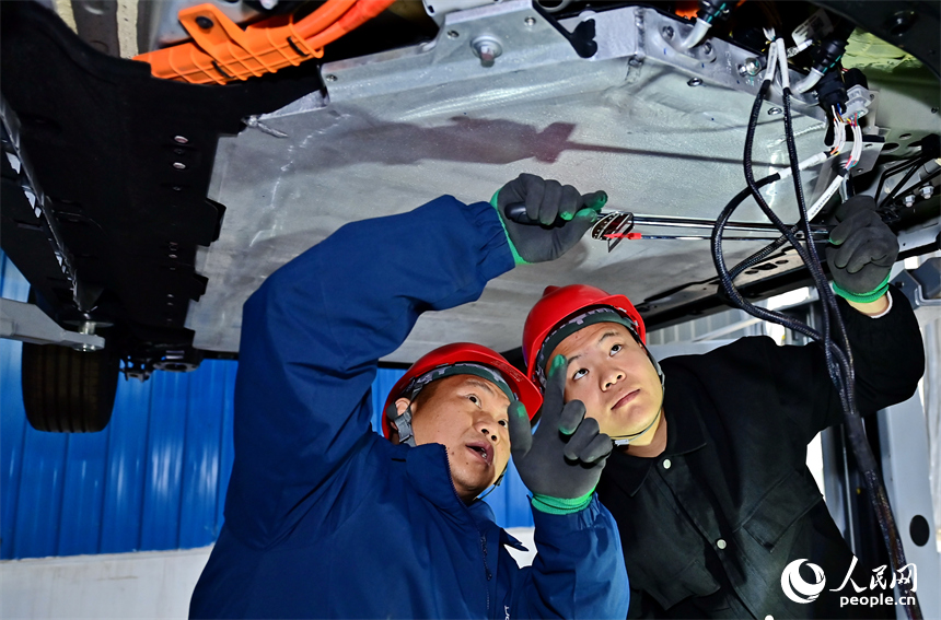 新能源汽車運維專業學生在老師的指導下學習新能源汽車電池包檢修技術。人民網 朱海鵬攝