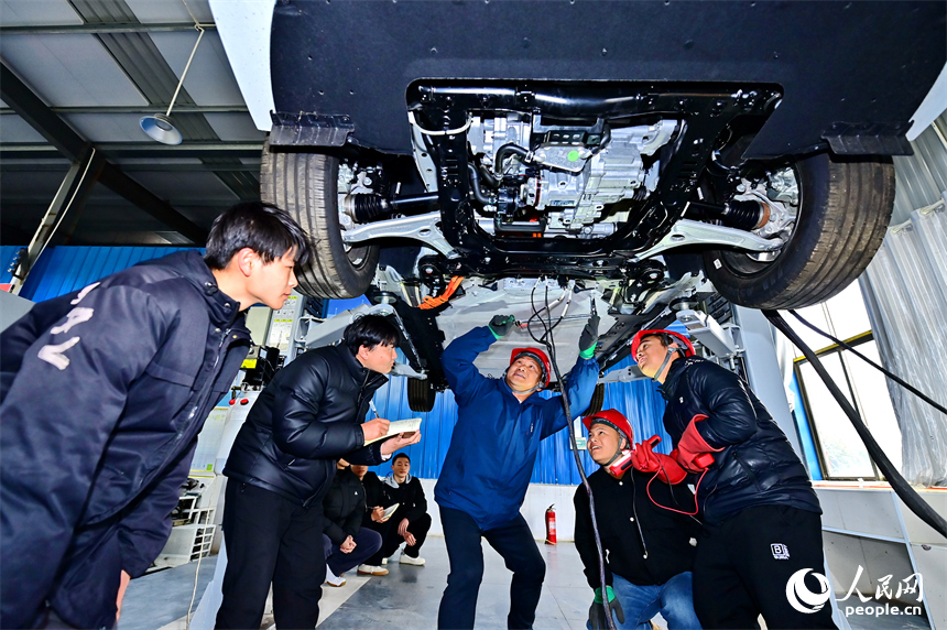 新能源汽車運維專業學生在老師的指導下學習新能源汽車電池包檢修技術。人民網 朱海鵬攝