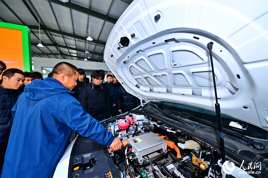 新能源汽車運維專業學生在老師的指導下學習新能源汽車電池包檢修技術。人民網 朱海鵬攝