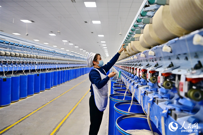 上高縣工業園區的一家民營紡織企業車間內，工人在智能紡紗生產線上加工出口訂單產品。人民網 朱海鵬攝
