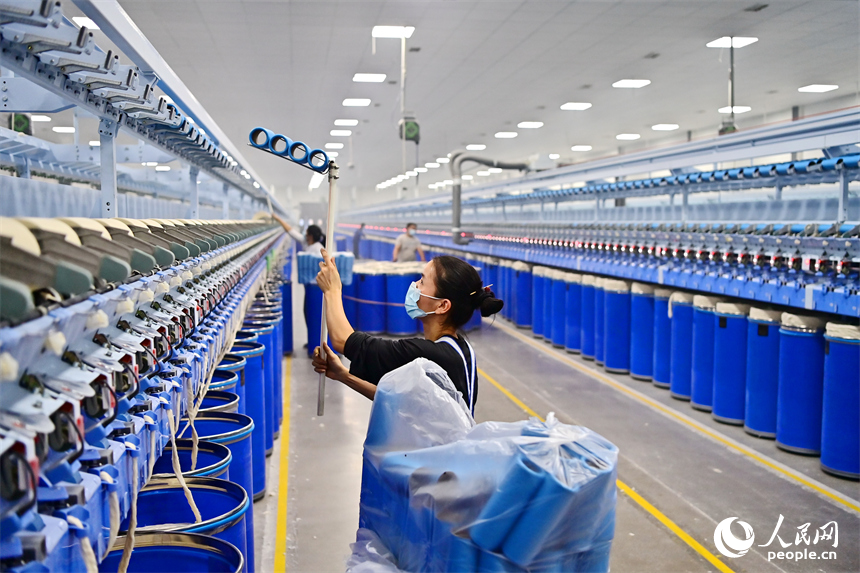 上高縣工業園區的一家民營紡織企業車間內，工人在智能紡紗生產線上加工出口訂單產品。人民網 朱海鵬攝