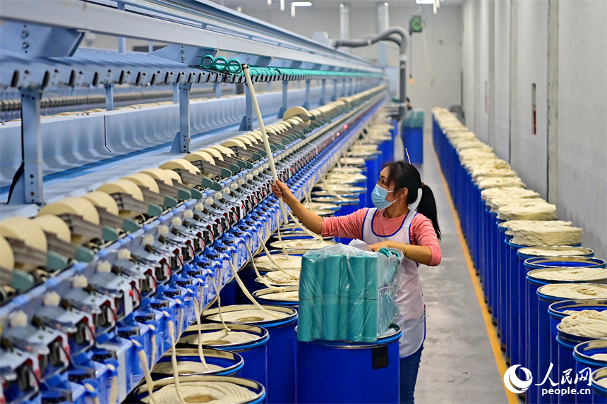 上高縣工業園區的一家民營紡織企業車間內，工人在智能紡紗生產線上加工出口訂單產品。人民網 朱海鵬攝