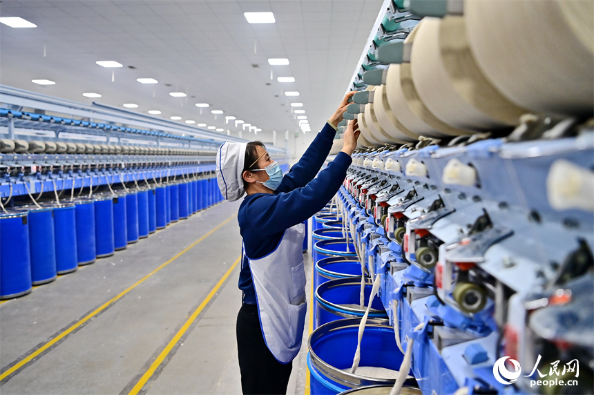 上高縣工業園區的一家民營紡織企業車間內，工人在智能紡紗生產線上加工出口訂單產品。人民網 朱海鵬攝