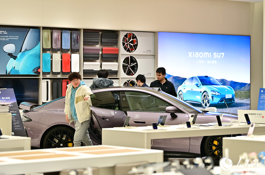 南昌市紅谷灘區的一家大型商場的汽車展示銷售區，不少顧客咨詢選購新能源汽車。人民網 朱海鵬攝