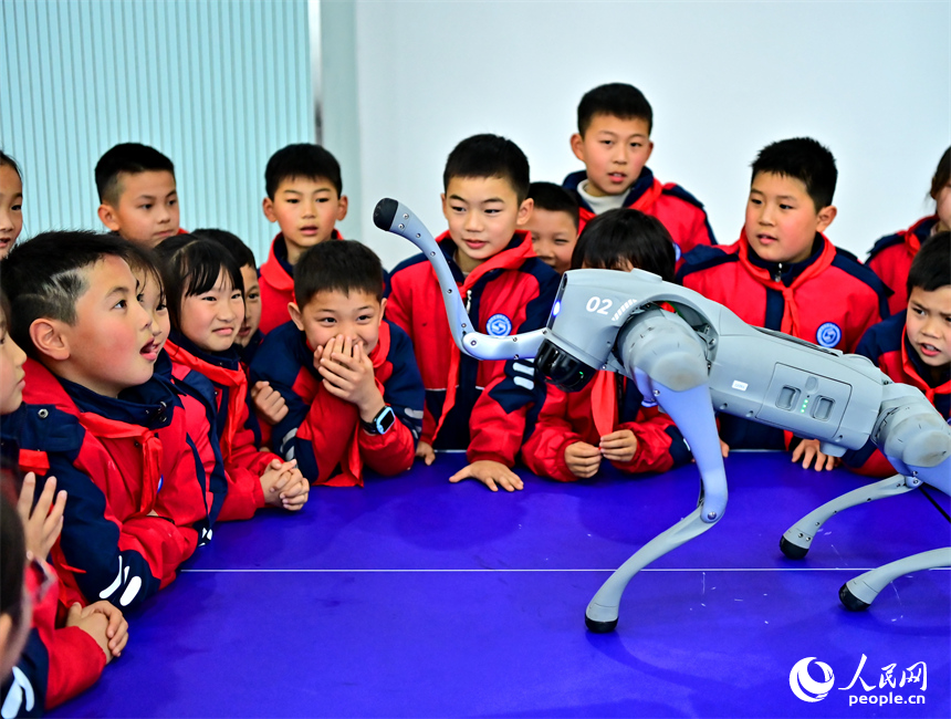 撫州市臨川區第五實驗學校人工智能科技小課堂上，學生在觀看仿生四足機器人表演。人民網 朱海鵬攝