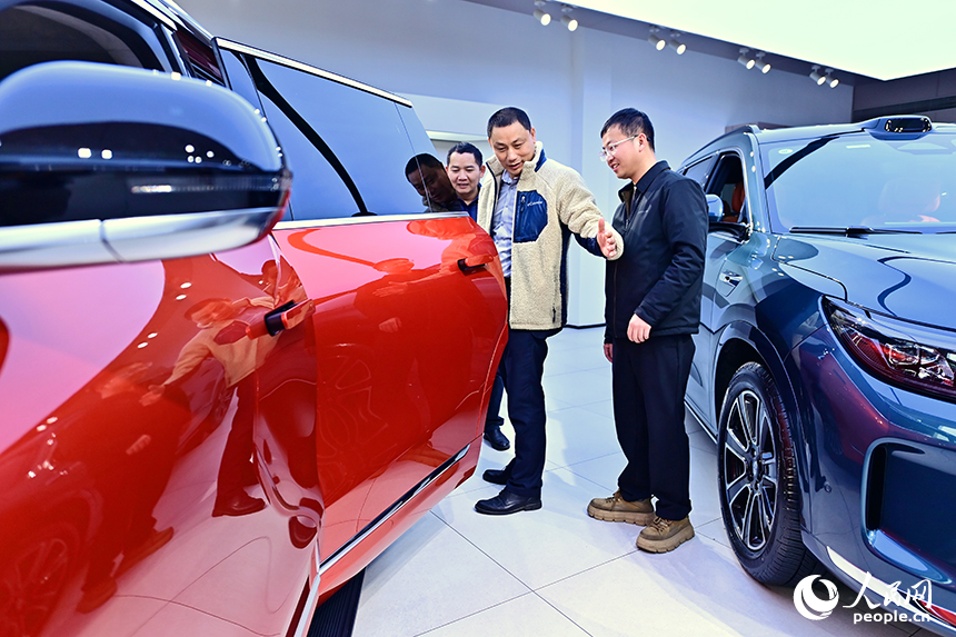 撫州市臨川區的一家國產新能源汽車銷售公司展廳，顧客在了解選購車型并咨詢汽車“以舊換新”補貼政策。人民網 朱海鵬攝