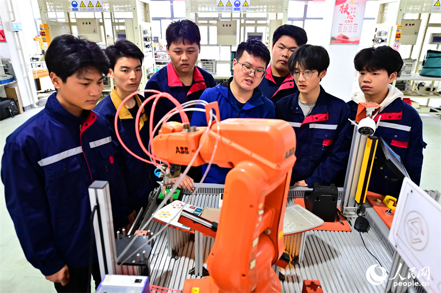 上饒市弋陽中等職業學校工業機器人實訓基地，學生在學習智能機械臂操作技能和編程知識。人民網 朱海鵬攝