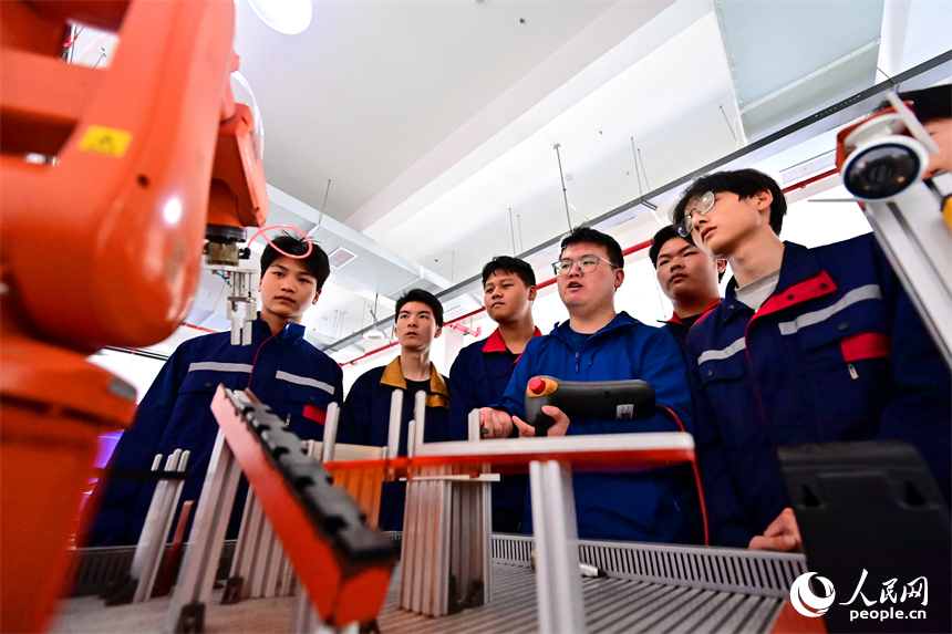 上饒市弋陽中等職業學校工業機器人實訓基地，學生在學習智能機械臂操作技能和編程知識。人民網 朱海鵬攝
