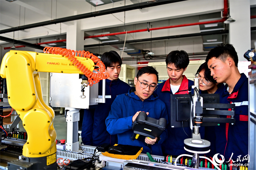 上饒市弋陽中等職業學校工業機器人實訓基地，學生在學習硬質合金零部件機械化加工技能。人民網 朱海鵬攝