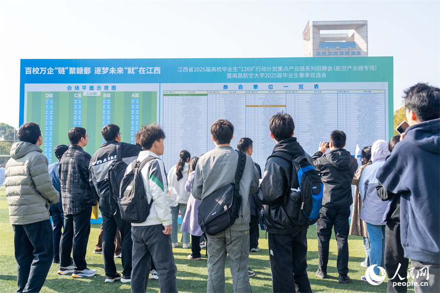 招聘會現場，求職者正在展板處查看參加企業。人民網 龍楚良攝