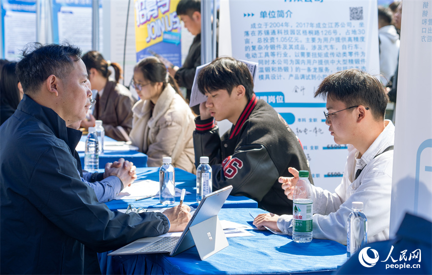 招聘會現場，用人單位正在與求職者交流。人民網 龍楚良攝