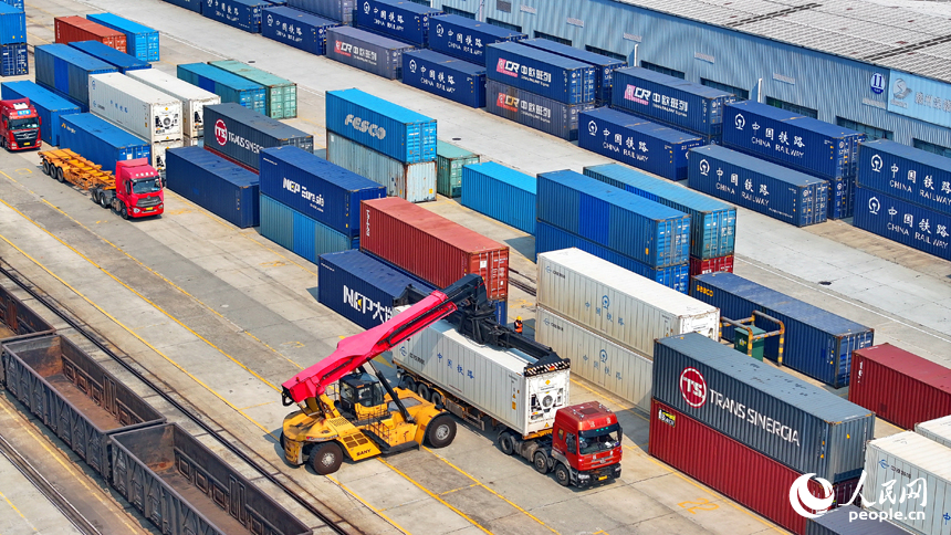 贛州國際陸港內的多式聯運貨物集裝箱裝運作業有序進行，貨場一派忙碌景象。人民網 朱海鵬攝