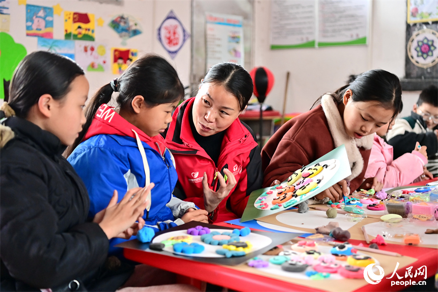 撫州市樂安縣湖溪鄉梅溪村“幼吾幼”少兒之家，當地慈善總會的志愿者和農村留守兒童一起交流互動，進行趣味粘土手工制作游戲。人民網 朱海鵬攝