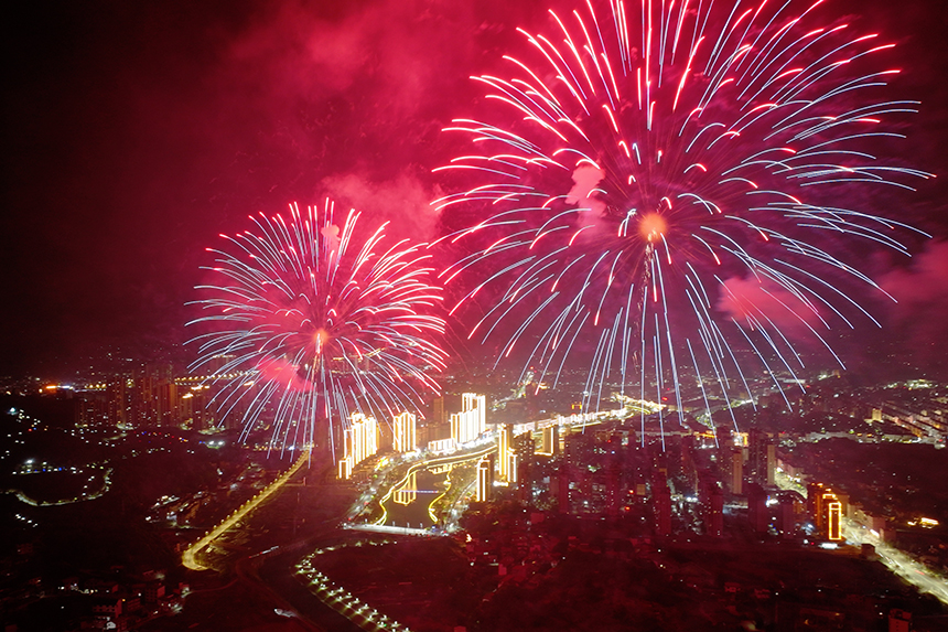 暖黃燈光與煙花交相呼應，勾勒出一幅溫馨又震撼的城市夜景。柳戈攝