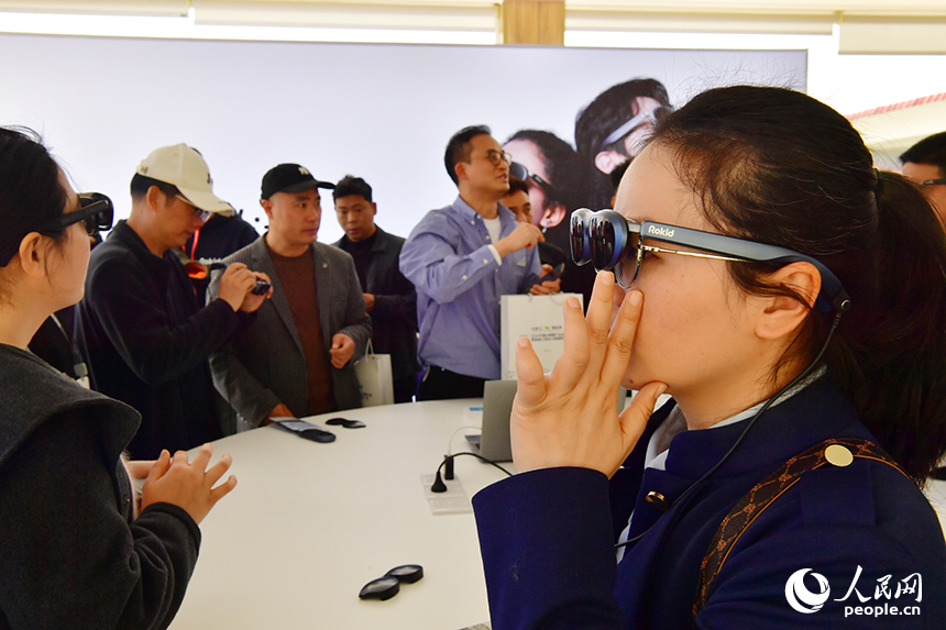 展臺前，人們正在體驗一款智慧眼鏡。人民網記者 時雨攝