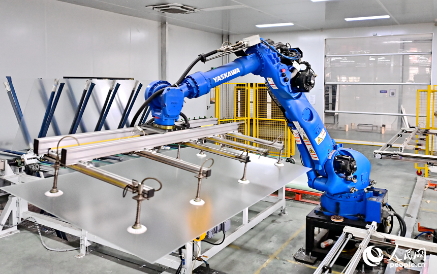 贛州市定南縣的一家新材料有限公司智能制造車間內，機器人手臂在來回循環作業，工人忙著加工光伏玻璃面板。人民網 朱海鵬攝