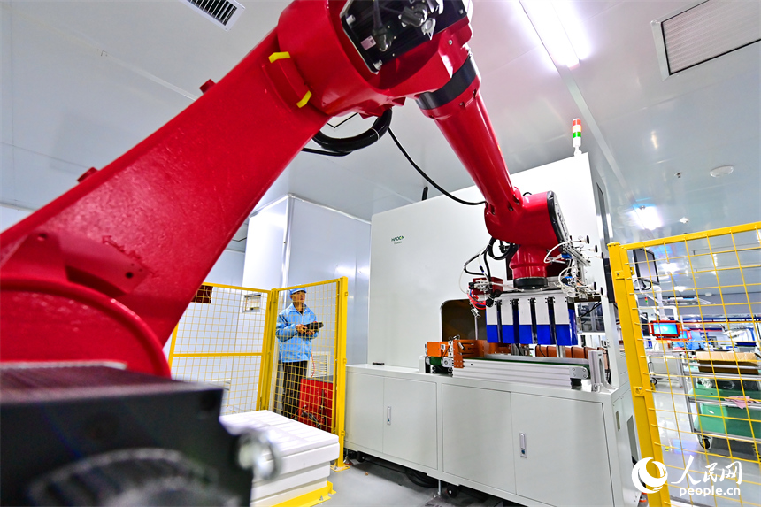 上饒市弋陽縣高新技術產業園區的科技企業車間內，工人在操作智能機械臂加工新能源汽車零部件。人民網 朱海鵬攝