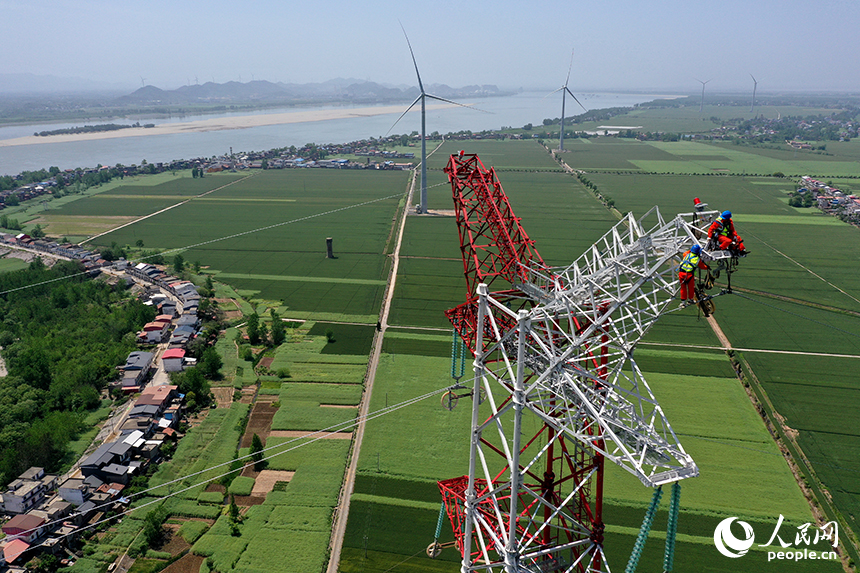 國家電網江西送變電中建公司施工人員正在電力鐵塔塔頂作業。人民網記者 時雨攝