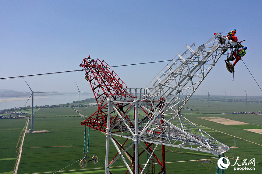 國家電網江西送變電中建公司施工人員正在電力鐵塔塔頂作業。人民網記者 時雨攝