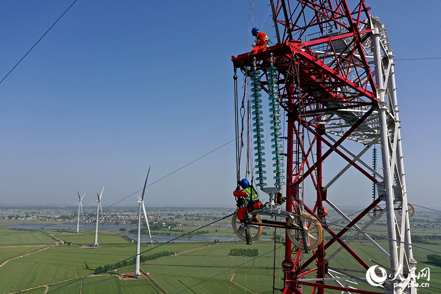 國家電網江西送變電中建公司施工人員正在電力鐵塔塔頂作業。人民網記者 時雨攝