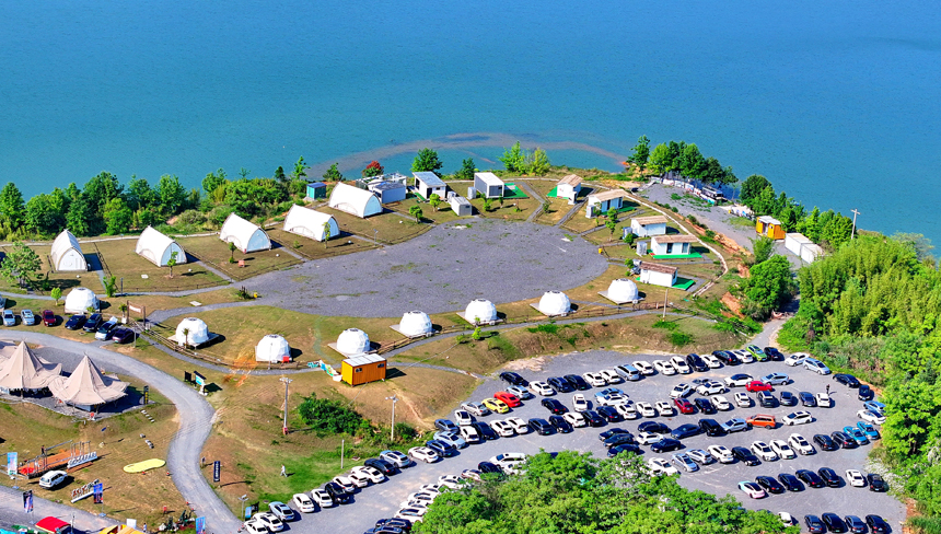 贛州市上猶縣的趣野南湖野奢營地，房車帳篷、露營帳篷鱗次櫛比，吸引眾多游客驅車前來游玩，暢享戶外露營樂趣。人民網 朱海鵬攝