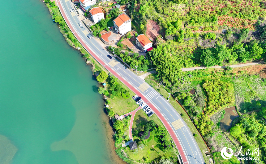 贛州市上猶縣東山鎮，車輛在環湖公路行駛，沿線水清岸綠景美春意濃。人民網 朱海鵬攝