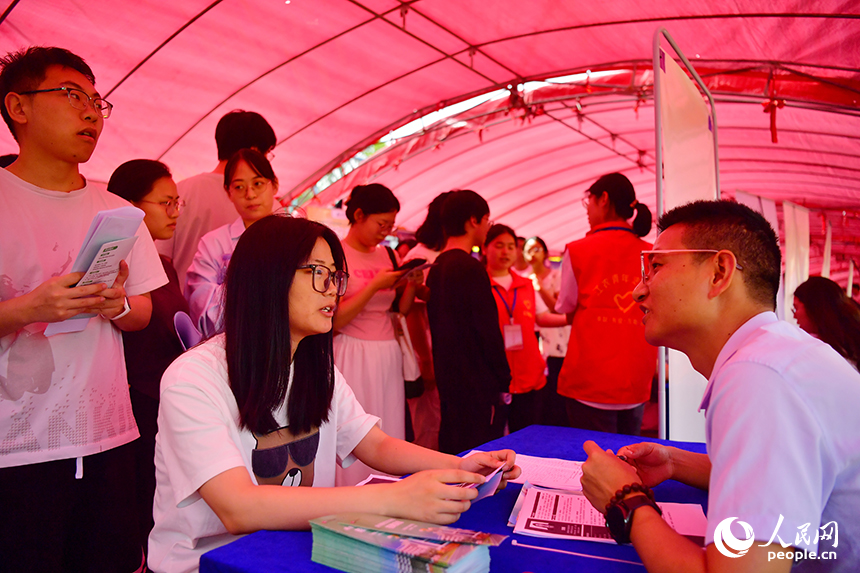 “國聘行動”現場，高校畢業生正在跟企業招聘人員交談。人民網記者 時雨攝