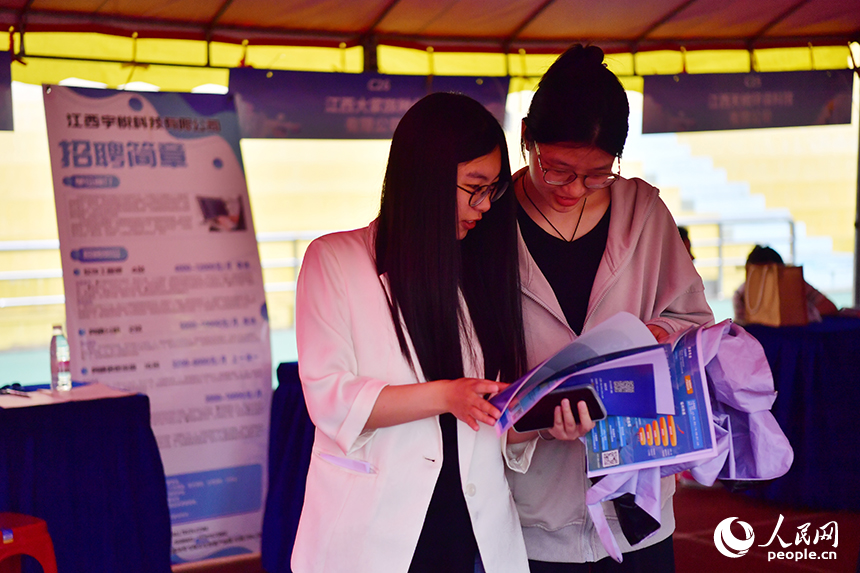 “國聘行動”現場，高校畢業生正在翻閱企業的招聘簡章。人民網記者 時雨攝