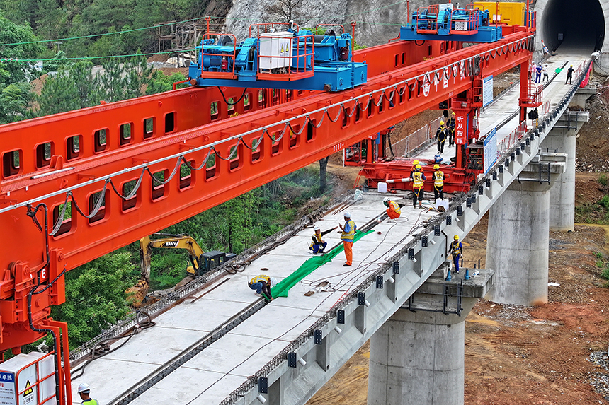 瑞金市澤覃鄉，大型架梁機平穩前移，工人在架設瑞梅鐵路橋梁。人民網 朱海鵬攝