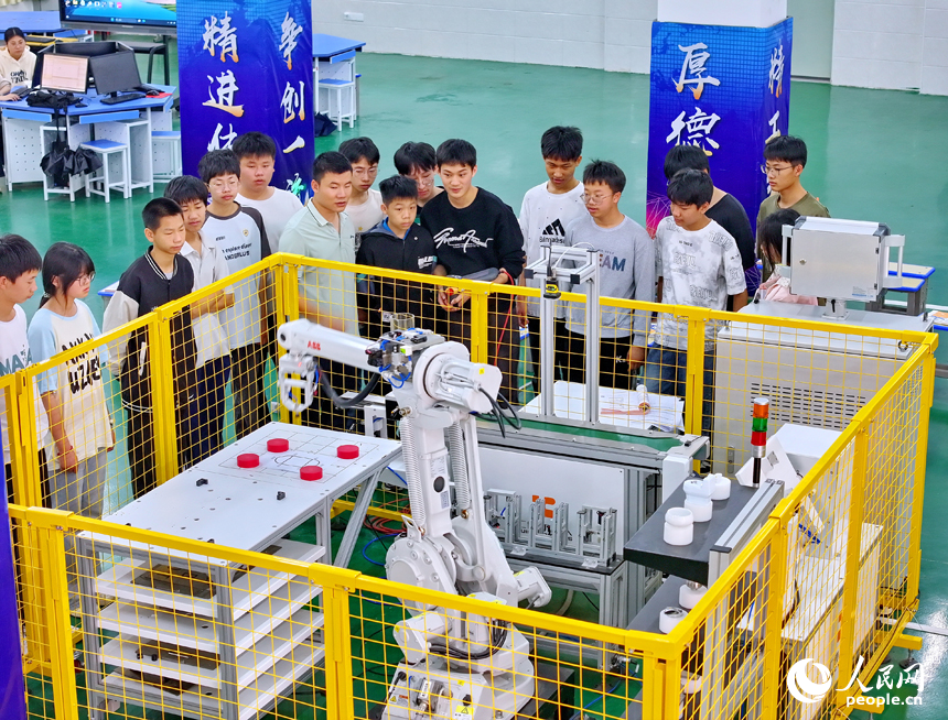 瑞金市瑞金中等專業學校工業機器人實訓基地，老師在指導學生在操作智能機械臂。人民網 朱海鵬攝