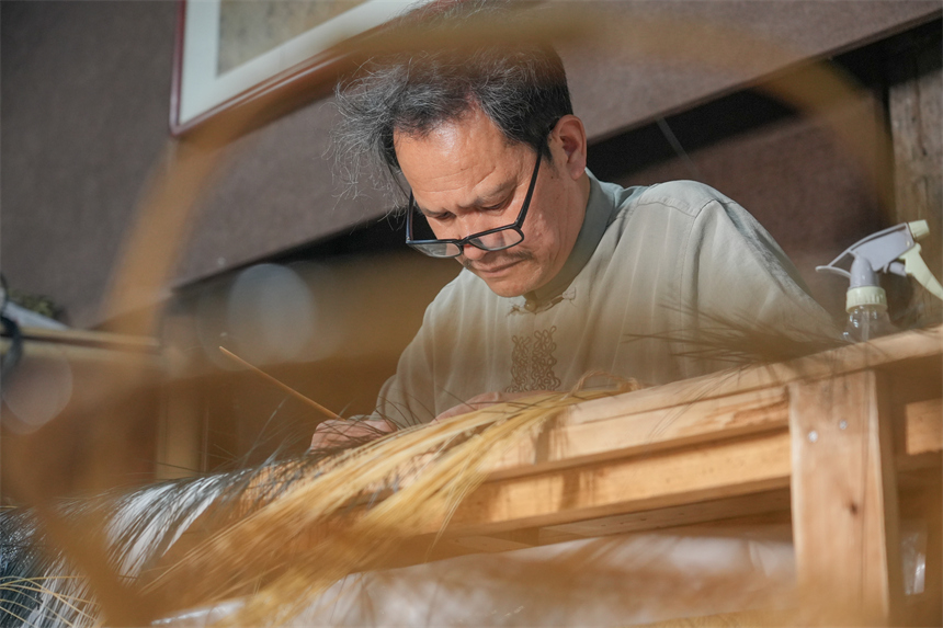 徐建元正在編織明代仇英版《清明上河圖》。人民網 孔文進攝