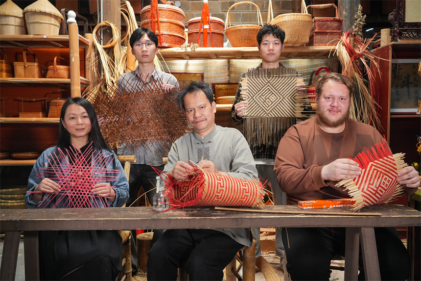 徐建元和學員們展示正在創作的篾編工藝品。人民網 孔文進攝