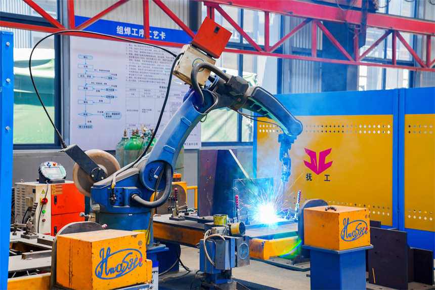 車間內，機械手臂正在焊接。郭昊攝