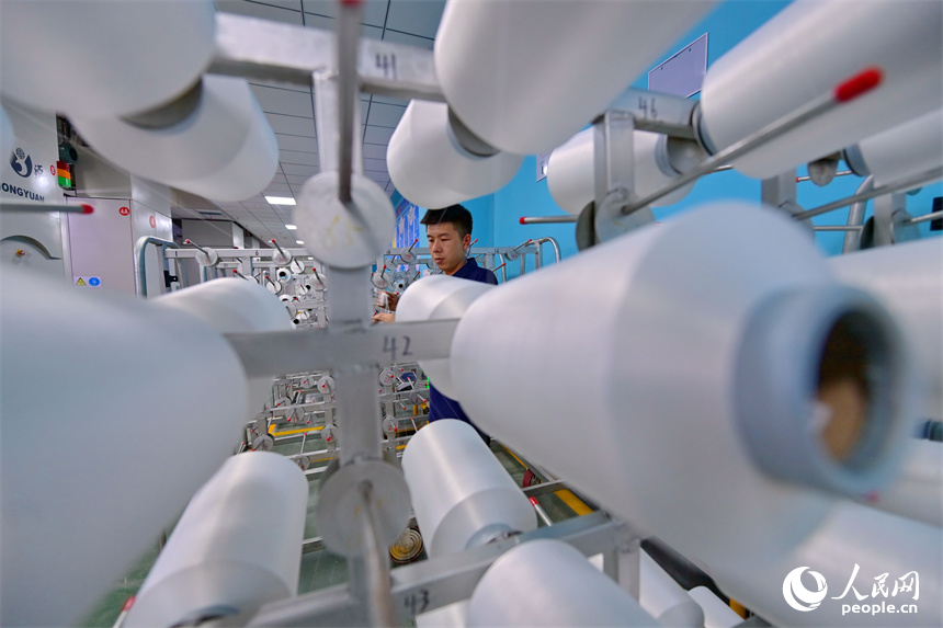 瑞金市的一家化纖紡織企業，工人在生產線上趕制出口東南亞國家的產品訂單。人民網 朱海鵬攝
