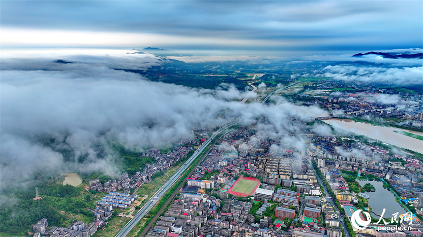 吉安市吉水縣城上空云霧繚繞，城市建筑、道路、橋梁、田園、河流在云霧的籠罩下，若隱若現，宛如仙境。人民網 朱海鵬攝