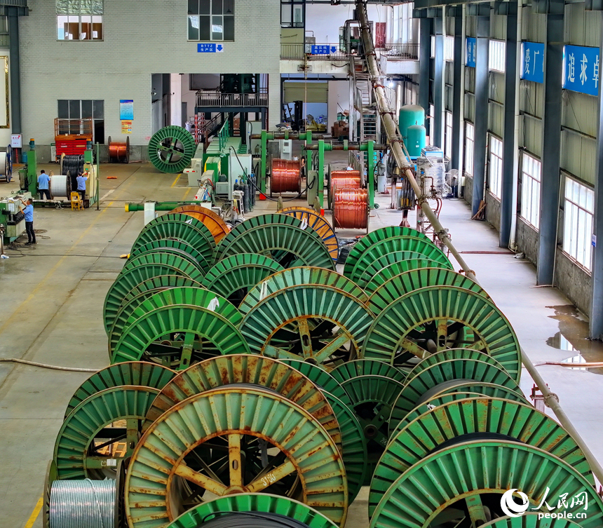 瑞金市經濟開發區的一家電線電纜企業智能制造車間內，工人在生產線上趕制出口的銅線訂單產品。人民網 朱海鵬攝