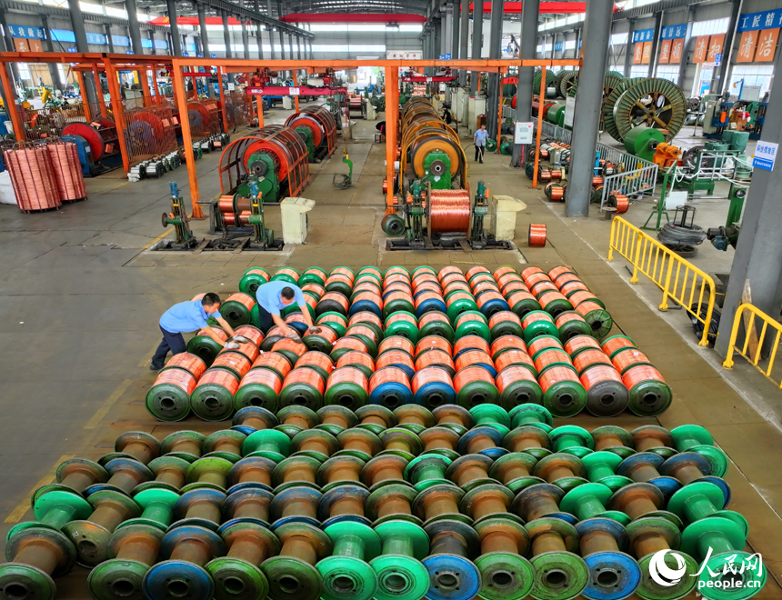 瑞金市經濟開發區的一家電線電纜企業智能制造車間內，工人在生產線上趕制出口的銅線訂單產品。人民網 朱海鵬攝