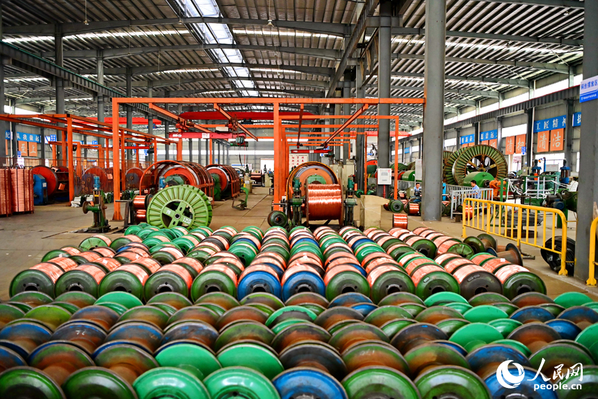 瑞金市經濟開發區的一家電線電纜企業智能制造車間內，工人在生產線上趕制出口的銅線訂單產品。人民網 朱海鵬攝