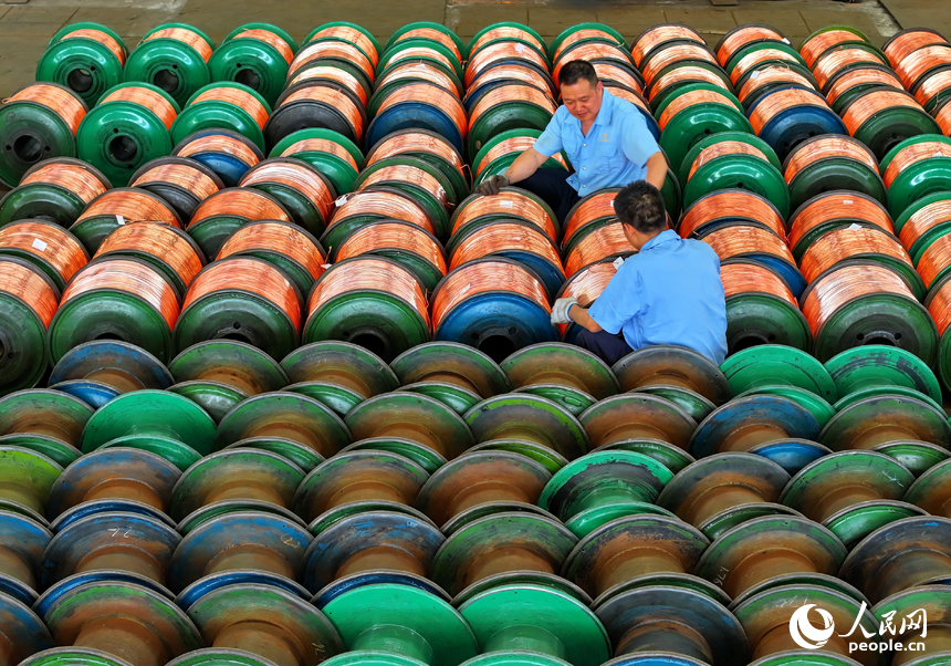 瑞金市經濟開發區的一家電線電纜企業智能制造車間內，工人在生產線上趕制出口的銅線訂單產品。人民網 朱海鵬攝