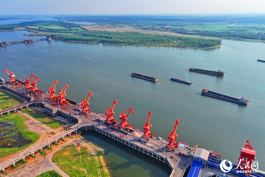 南昌市南昌縣富山鄉贛江河畔，姚灣綜合碼頭船來船往，裝卸運輸設備有序運轉，一派繁忙景象。人民網 朱海鵬攝