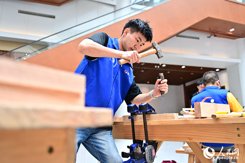 贛州市南康區家居小鎮博覽中心，幾十名木匠工人在手工木工（木制家具工）職業技能競賽決賽中制作家具。人民網 朱海鵬攝