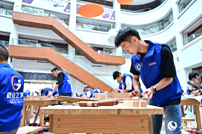 贛州市南康區家居小鎮博覽中心，幾十名木匠工人在手工木工（木制家具工）職業技能競賽決賽中制作家具。人民網 朱海鵬攝